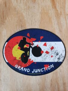 Grand junction Mountain Bike rider exploding out of a distressed Colorado Flag