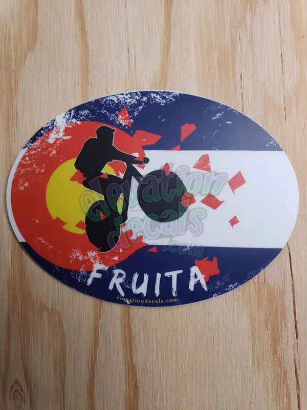 Fruita silhouette Mountain Biker exploding out of a distressed Colorado Flag